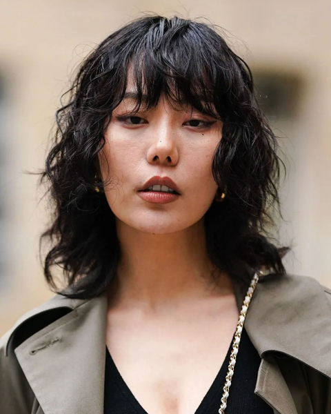 Model with shag haircut wearing a trench coat